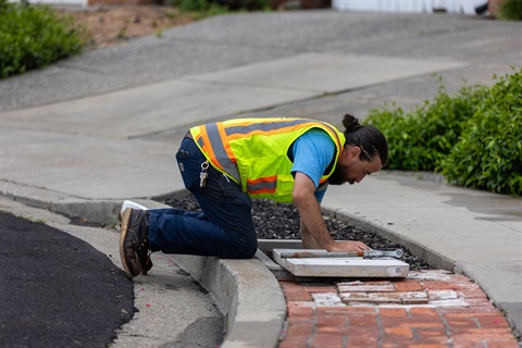 Employee inspects water line for lead